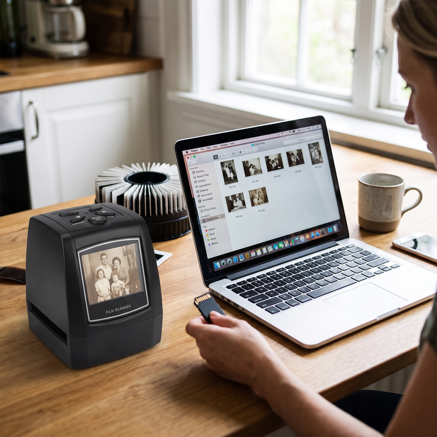 Memory card being taken out of the scanner beside a laptop and phone